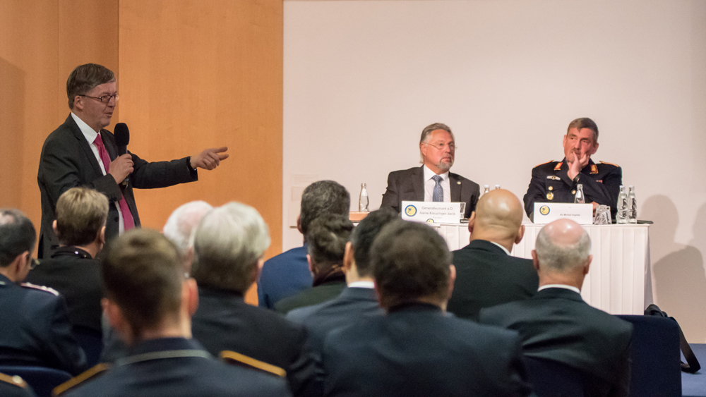 Foto: „Wir brauchen eine Architektur aus verschiedenen Systemen, die es uns erlaubt, den Kampfhubschrauber, der wenige hundert Meter vor einem Kampfverband des Heeres aus der Deckung kommt, genauso verlässlich zu bekämpfen, wie einen ballistischen Flugkörper, der sich beinahe senkrecht auf die logistische Basis im Einsatzgebiet stürzt.“ Brigadegeneral Hogrebe stellte klare Forderungen an die zukünftige Luftverteidigung. Die Interessengemeinschaft Deutsche Luftwaffe e.V. hatte zur ihrer ersten Berliner Plattform in diesem Jahr geladen. Das aktuelle Thema „Bodengebundene Luftverteidigung - Sachstand und Perspektiven“ hatte zahlreiche Vertreter aus Politik, Militär und Industrie in die Landesvertretung Sachsen-Anhalt nach Berlin gelockt. Auch der Wehrbeauftragte des Deutschen Bundestags, Dr. Hans-Peter Bartels, befand sich unter den interessierten Zuhörern. Das Spektrum, das unsere Streitkräfte heute bedroht, reicht von der Minidrohne bis hin zu ballistischen Flugkörpern großer Reichweite. Brigadegeneral Hogrebe unterstrich, dass diesem komplexen Szenario nur teilstreitkraftübergreifend und in einem multinationalen Ansatz begegnet werden könne. Der Schutz von Landstreitkräften werde durch weitreichende Waffensysteme in Form eines dynamischen Raumschutzes, lageabhängig auch mit Unterstützung luftgestützter Luftverteidigungskräfte, sichergestellt. Die Integration der landgestützten Systeme zur Flugkörperabwehr in der unteren Abfangschicht mit den Sensoren der Marine sei ein weiteres Beispiel effektiver Abwehrmaßnahmen. Im Bereich der multinationalen Zusammenarbeit sei die Aufstellung einer Multinational Air and Missile Defence Task Force das strategische Ziel. Darüber hinaus berichtete er von den derzeitigen bilateralen Kooperationsabsichten mit den Niederlanden und Polen. Mit Blick in die Zukunft sei es wichtig, das in der Luftwaffe befindliche PATRIOT System für multinationale Einsätze weiterhin auf modernstem Stand zu halten und so die Zeit bis zur Verfügbarkeit eines Taktischen Luftverteidigungssystems (TLVS) optimal überbrücken zu können, so der Brigadegeneral. Darüber hinaus sei die Sicherstellung des Nah- und Nächstbereichsschutz essentiell, um dem akut gestiegenen Schutzbedürfnisses der Landstreitkräfte Rechnung zu tragen. Unter Leitung des Präsidenten der Interessengemeinschaft Deutsche Luftwaffe e.V. Generalleutnant a.D. Aarne Kreuzinger-Janik folgte eine äußerst lebhafte Diskussion. Großen Beifall erhielt der Wehrbeauftragte des Deutschen Bundestags. Er betonte, dass die Herausforderung für die Luftwaffe jetzt da seien. „Und wir sagen dann in 10 Jahren haben wir eine Lösung dafür, das ist zu lang.“ Dr. Hans-Peter Bartels hatte in seinem letzten Jahresbericht das mangelnde Tempo bei Rüstungsvorhaben kritisiert. „Die Diskussion hat gezeigt, dass es höchste Zeit war, sich mit dem wichtigen Thema auseinanderzusetzen.“ resümierte Generalleutnant a.D. Aarne Kreuzinger-Janik zufrieden am Ende der Veranstaltung. Text: Dr. Thorsten Weber Fotos: Astrid Burger-Weber